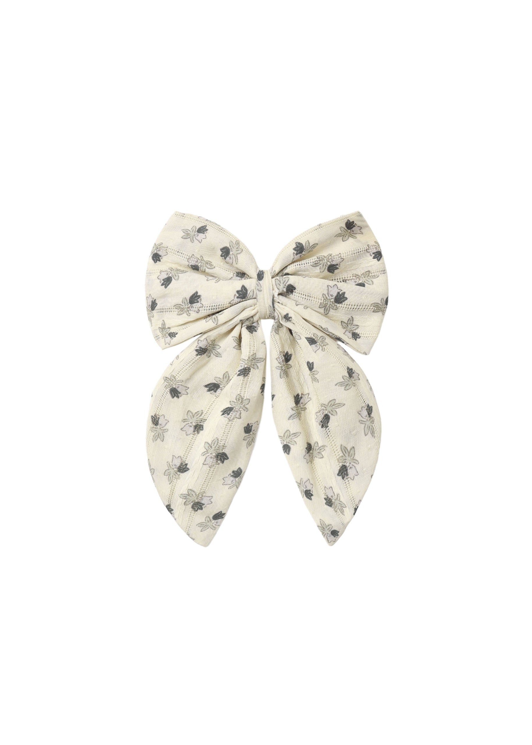 A cream-colored fabric hair bow with a delicate gray floral pattern, photographed flat against a solid white background.