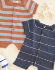 Two striped baby rompers, one orange and gray, the other blue and white, on a light background.