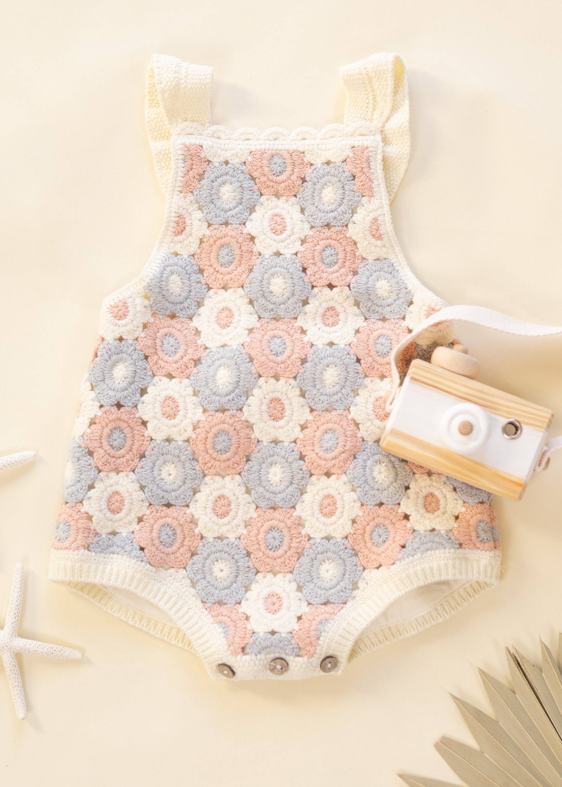 Baby romper with floral pattern on a beige background