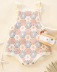 Baby romper with floral pattern on a beige background