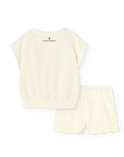 Set of cream-colored top and shorts with a brand logo on a white background