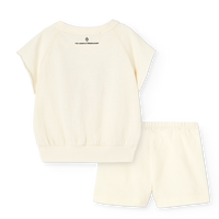 Set of cream-colored top and shorts with a brand logo on a white background
