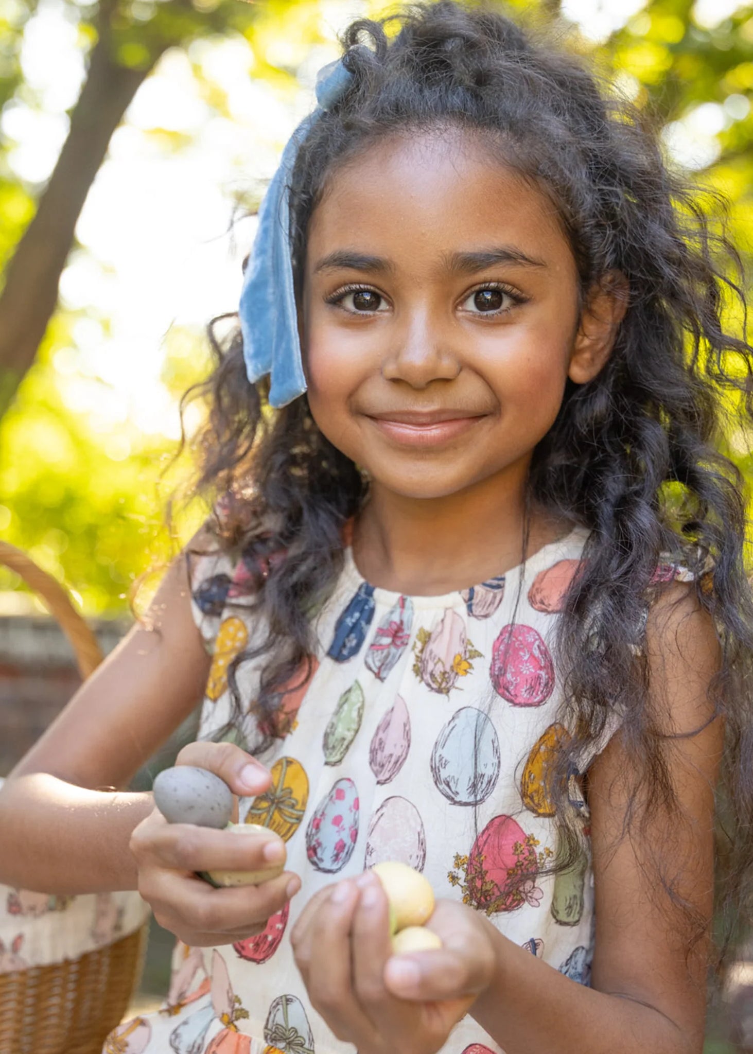 Young girl holding stones outdoors with a blurred background