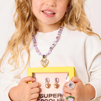 Young girl holding a display of jewelry with 'Super Smales' branding.