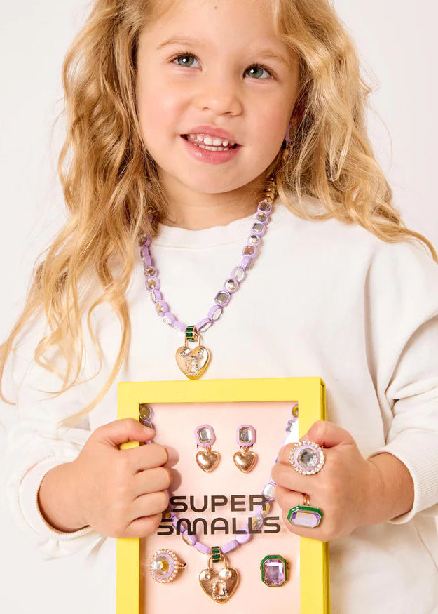Young girl holding a display of jewelry with 'Super Smales' branding.