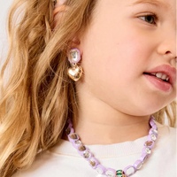 Young girl wearing a colorful necklace and earrings with a white background