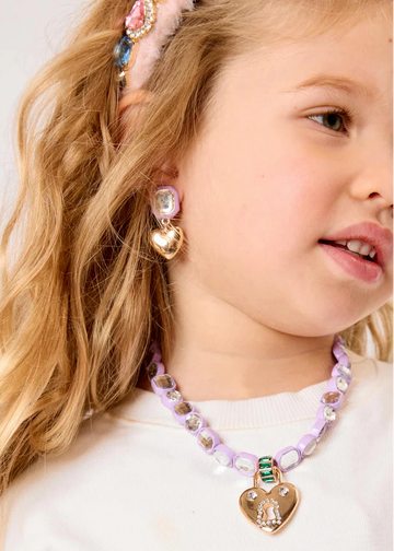 Young girl wearing a colorful necklace and earrings with a white background