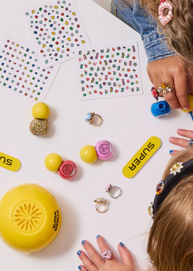 Children playing with colorful rings and stamps on a white surface