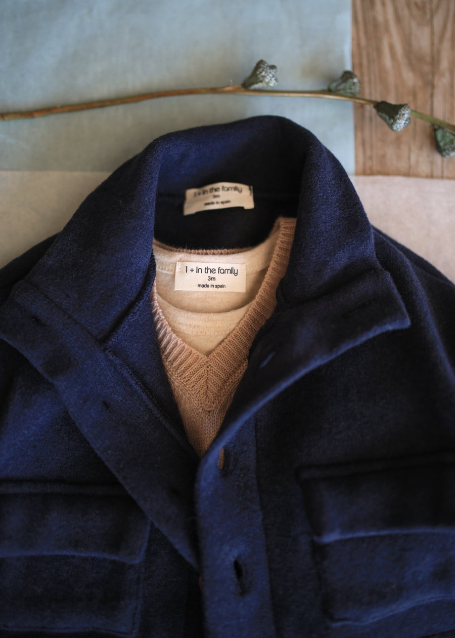 Navy blue coat with a brown vest and visible brand label on a neutral background