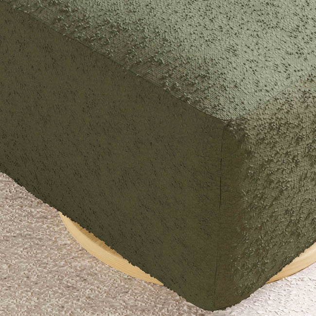 Close-up of a textured green fabric corner on a neutral background