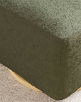 Close-up of a textured green fabric corner on a neutral background