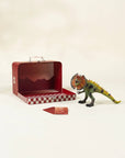 Toy dinosaur next to a red checkered box on a beige background