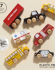 Set of toy vehicles including a van, taxi, fire truck, ambulance, school bus, and police car on a beige background.