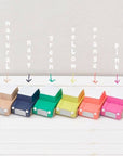 Set of colorful paper boxes labeled with color names on a white background