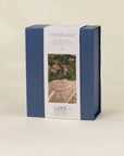A rectangular product box for Coco Village hair jewelry, featuring a navy blue side design and a white front label with a photo of a pearl hairpiece and a ring, set against a plain beige background.