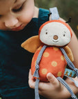 Child holding a plush toy with a blurred natural background