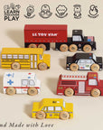Set of wooden toy vehicles including a truck, school bus, ambulance, and taxi on a beige background with 'Le Toy Van' branding.