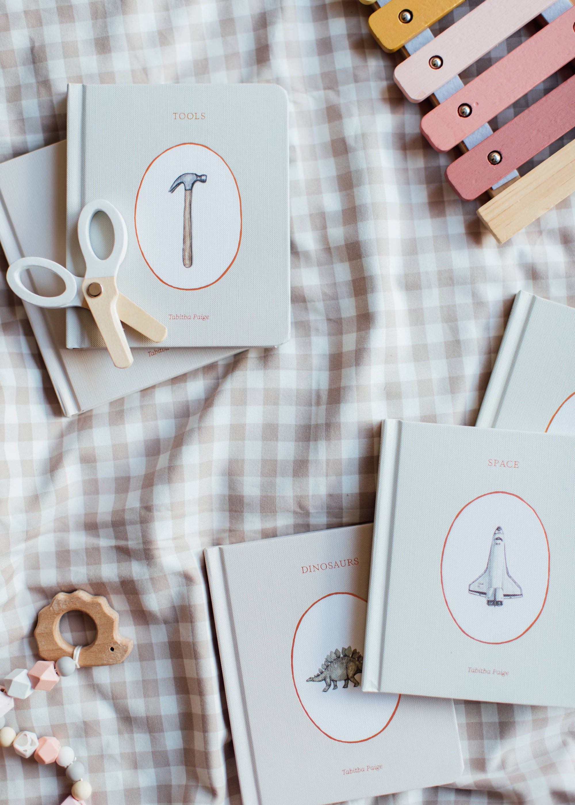 Children's books with illustrations of tools and toys on a checkered fabric background