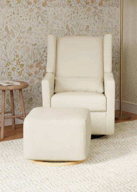 Beige armchair with matching ottoman in a room with floral wallpaper.