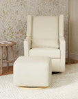 Beige armchair with matching ottoman in a room with floral wallpaper.