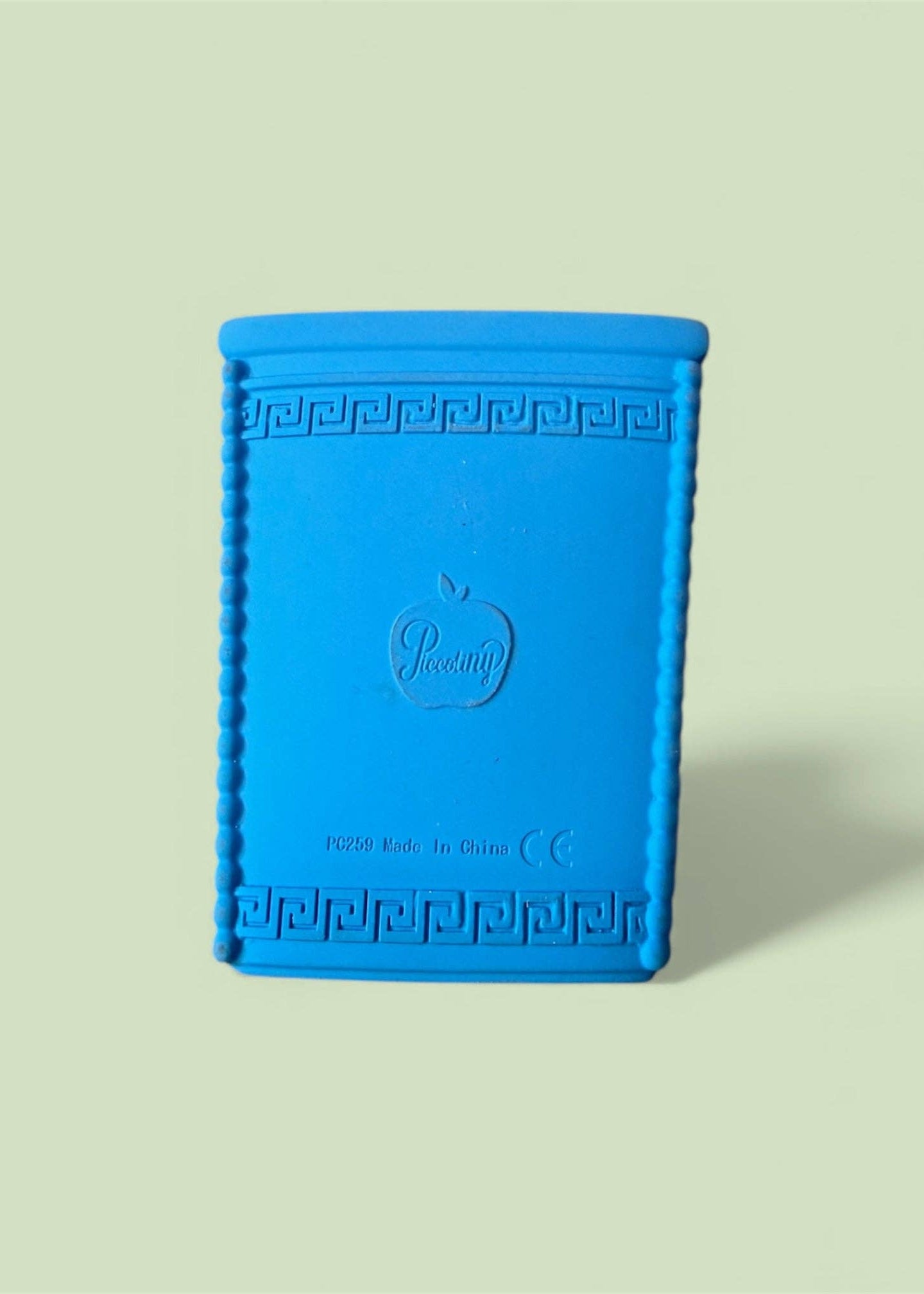 Blue textured book-shaped object with a brand logo on a light green background