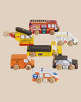 Set of colorful toy vehicles including a fire truck, ambulance, helicopter, and police car on a beige background.