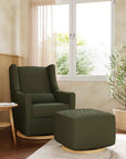 Green armchair and ottoman in a living room with a window and plants.