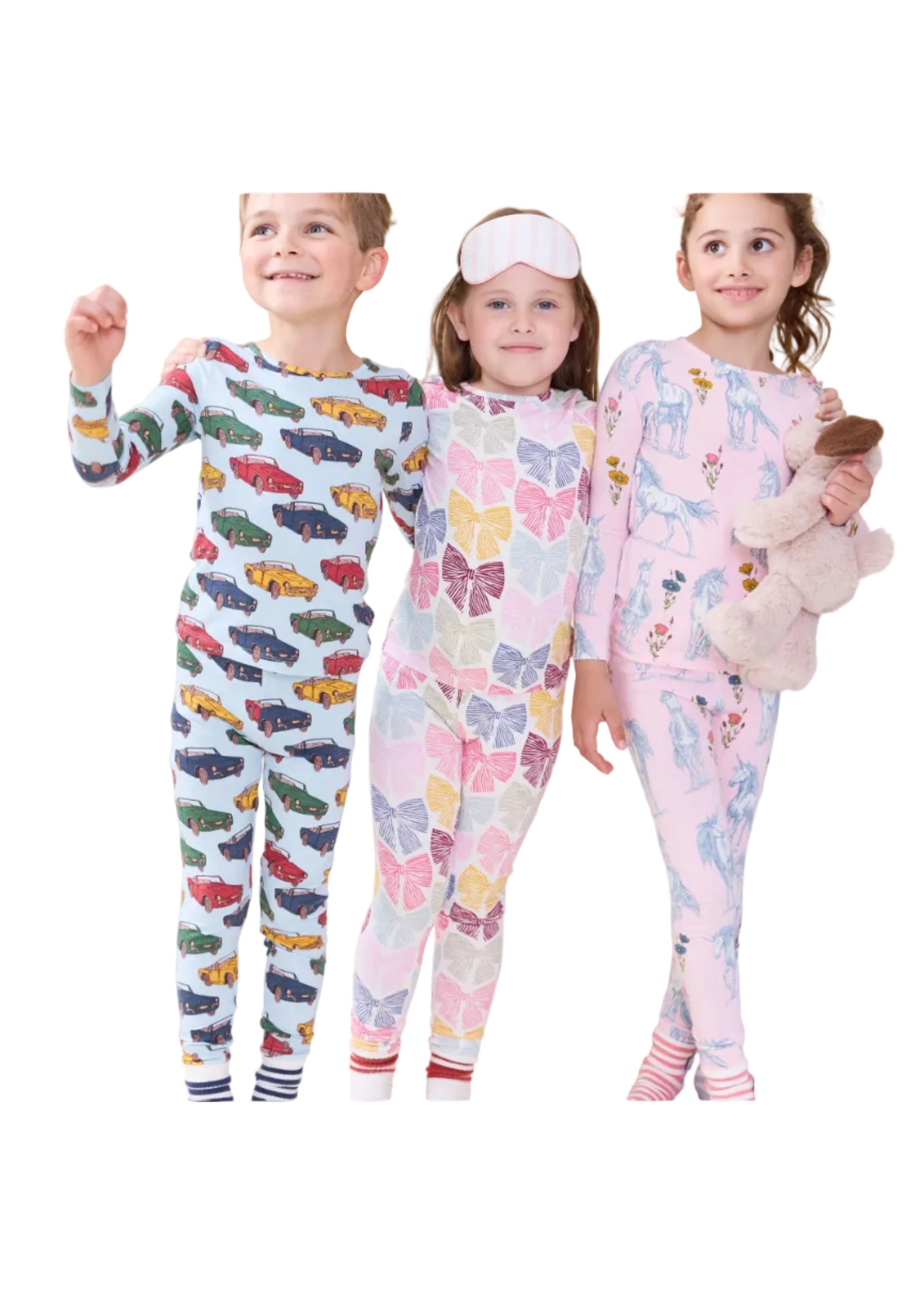 Three children wearing matching long-sleeve pajama sets with colorful animal and geometric prints, standing in a bedroom setting.