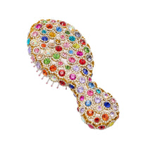 Multicolored jeweled hairbrush on a white background