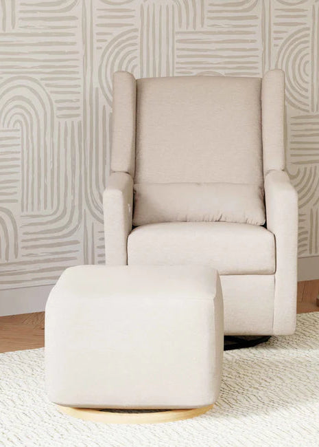 Beige armchair with matching ottoman against a patterned wall.