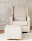 Beige armchair with matching ottoman against a patterned wall.