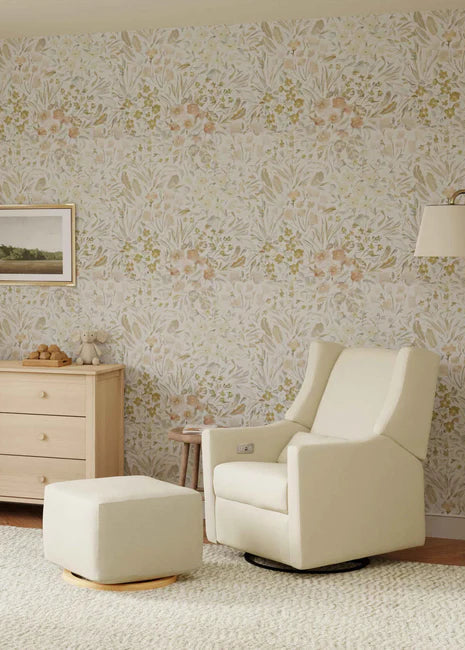 Living room with cream armchair, ottoman, and dresser against a floral wallpapered wall.