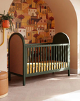 Nursery room with a green crib, decorative wall, and large window.