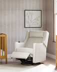 White recliner chair in a nursery with wooden crib and changing table.