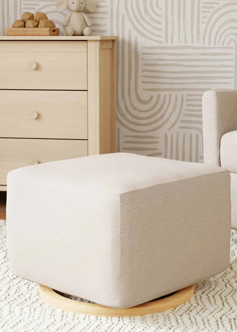 Beige ottoman in a living room setting with a sofa and dresser.