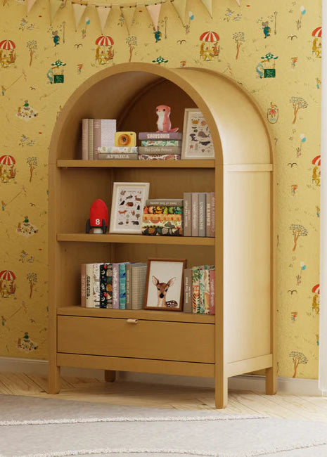 Wooden bookshelf with books and decor against a yellow wallpapered wall.