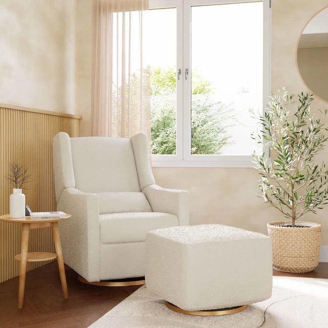 White armchair and ottoman in a bright living room with a window and plants.