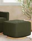 Green upholstered armchair and ottoman in a room with a plant and window.