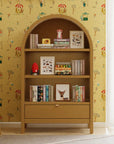 Wooden bookshelf with decorative items against a patterned wall.